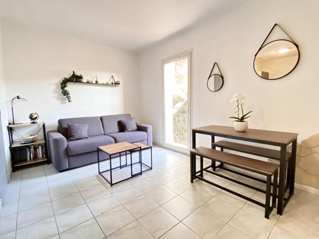 un salon avec un canapé violet et une table dans l'établissement Appartement dans villa à 600m de la plage, à Fréjus