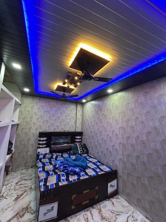 a bedroom with a bed with a blue lighting at KumbhaLivingg in Prayagraj