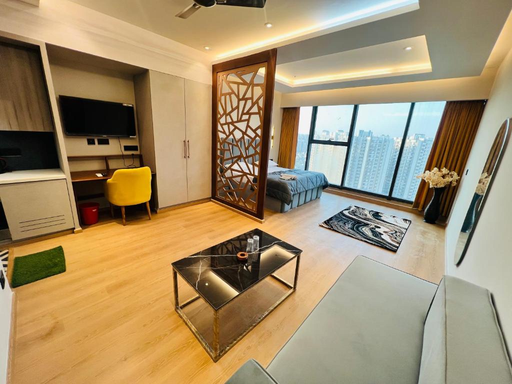 a living room with a couch and a glass table at Luxurious Suite with Panoramic glass wall in Ghaziabad