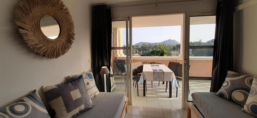 un salon avec un canapé, une table et un miroir dans l'établissement Résidence le Village de Cap Esterel - maeva Home - Appartement 2 Pièces 5 Personnes - Vue mer - Sélection MAE-5414, à Saint-Raphaël