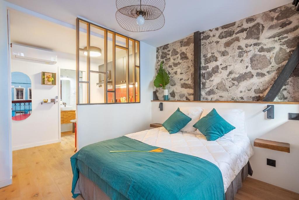 una camera da letto con un grande letto con cuscini blu di Résidence Nokoshima a Fort-de-France
