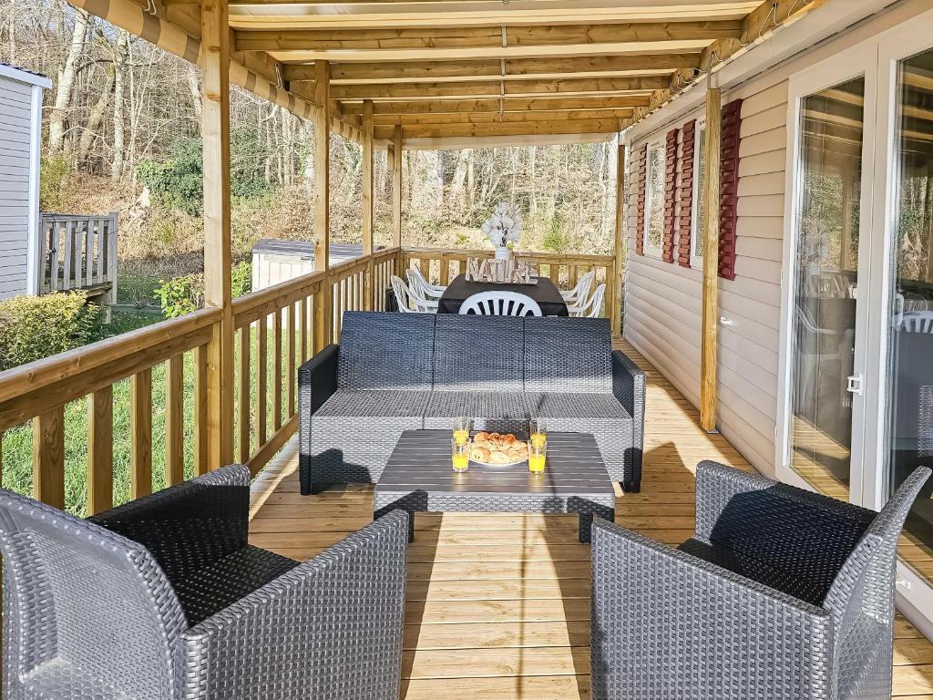 a screened porch with furniture and a fire pit at Nature & Sérénité in Litteau