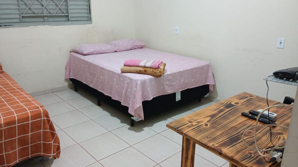 1 dormitorio con 1 cama con 2 almohadas y mesa en Hotel - Pousada e Restaurante Dona Benta, en Novo Acordo