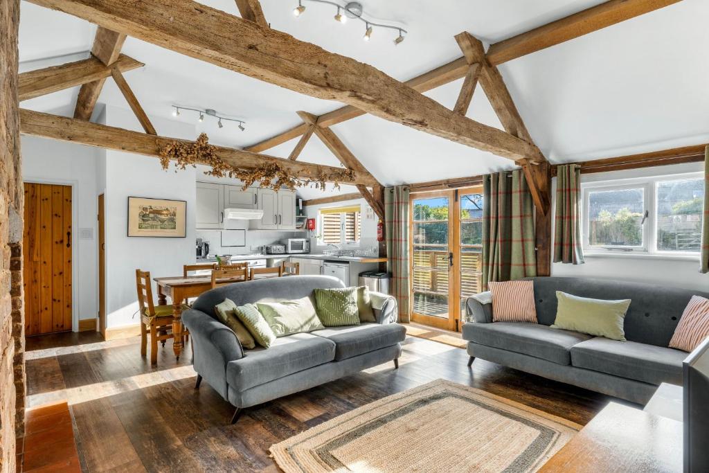 a living room with two couches and a kitchen at Long Barn in Little Marcle