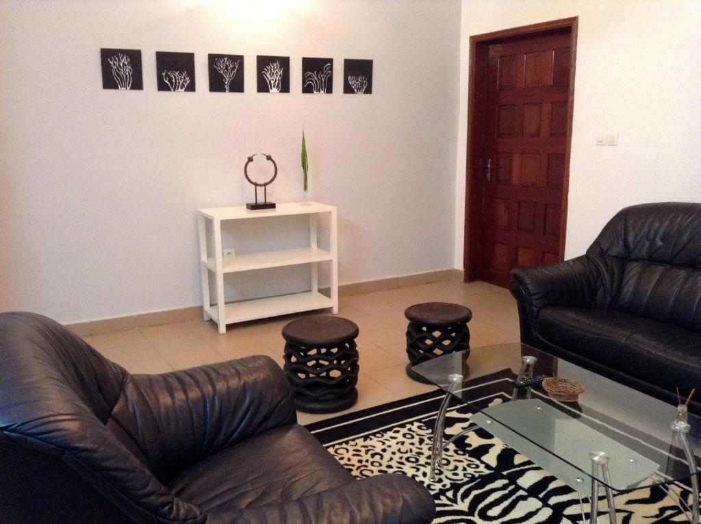 a living room with two leather chairs and a table at Bolo Residence Douala in Douala