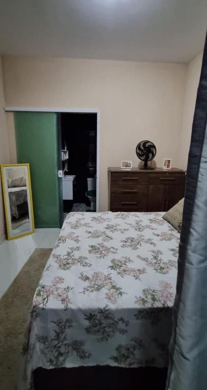 a bedroom with a bed with a flowered blanket at Ilhéus Bahia beach houseia in Ilhéus