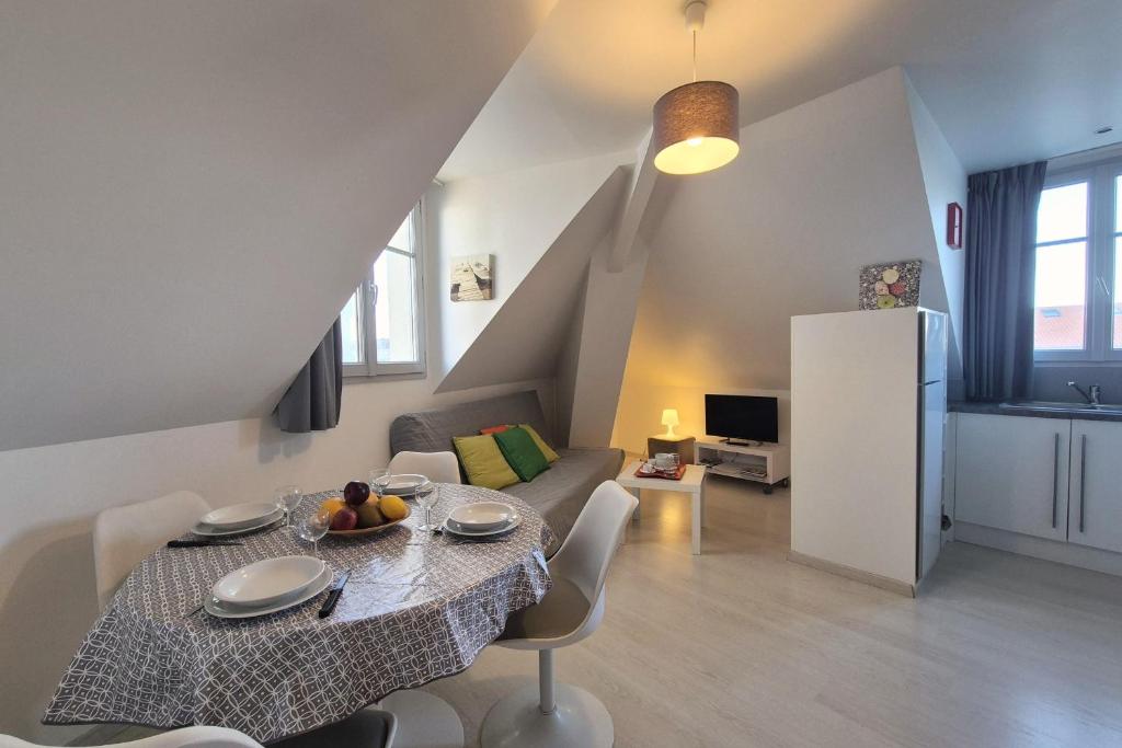un salon avec une table et un canapé dans l'établissement Appartement bord de plage avec piscine, à Les Sables-dʼOlonne
