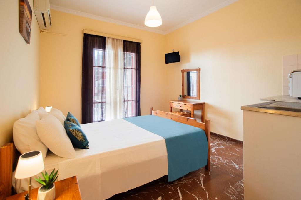 Un dormitorio pequeño con una cama y una ventana. en Levante Studios, en Benitses