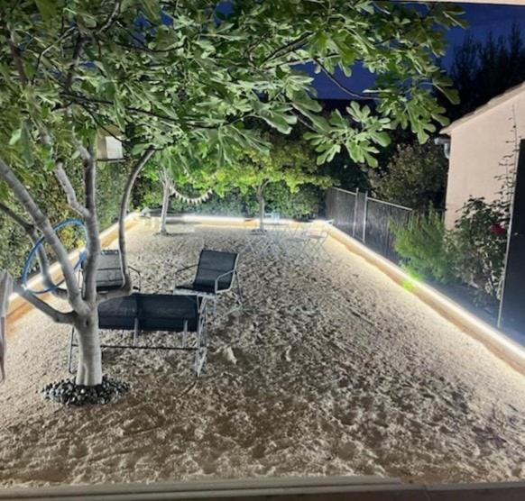 FlassanGîte La Chouette Hulotte classé 3 étoiles Spa, Mt Ventoux, Parc Spirou的几把椅子坐在树边