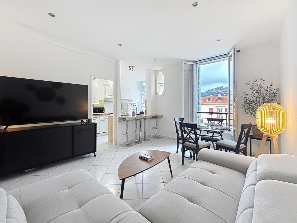 un salon avec un canapé blanc et une télévision dans l'établissement Nice Carlone Appart 6 pers, Clim, proche mer, transports, à Nice