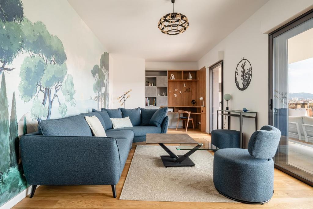 un salon avec un canapé bleu et deux chaises dans l'établissement Saint Victor, double terrasse vue sur le vieux port, à Marseille