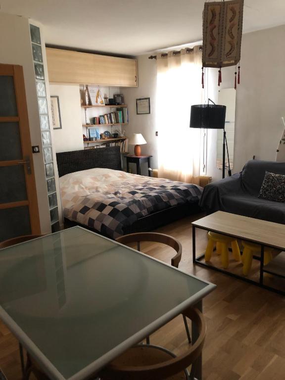 un salon avec un lit et une table dans l'établissement Lovely studio Heart of Paris, à Paris