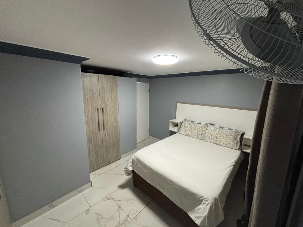 a bedroom with a bed and a fan on the wall at BEREA apartment 786 in Durban