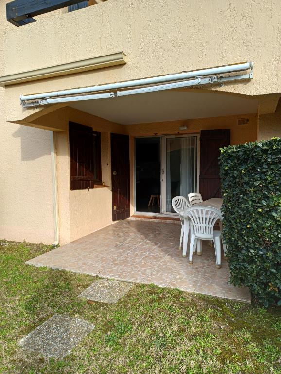 une terrasse avec une table et des chaises sur une maison dans l'établissement Logement Coquelicot, à Saint-Cyprien