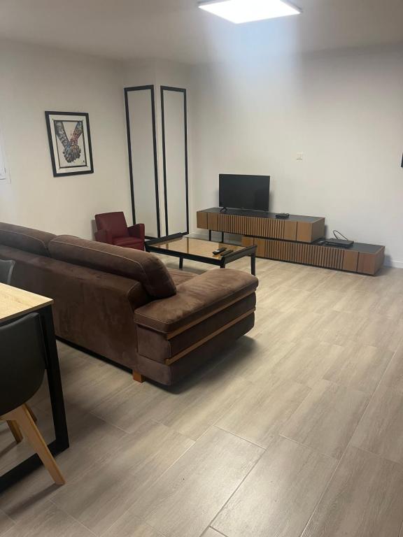 un salon avec un canapé et une table dans l'établissement Appartement entier 1 à 4 personnes au calme avec parking gratuit, à Nîmes