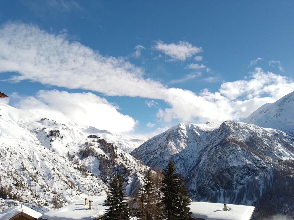 - une vue sur une chaîne de montagnes enneigée avec des arbres dans l'établissement Appartement avec vue montagne, à Forest des Baniols