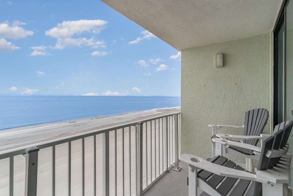 a pair of chairs sitting on a balcony overlooking the ocean at Sands Beach Club 922 in Myrtle Beach