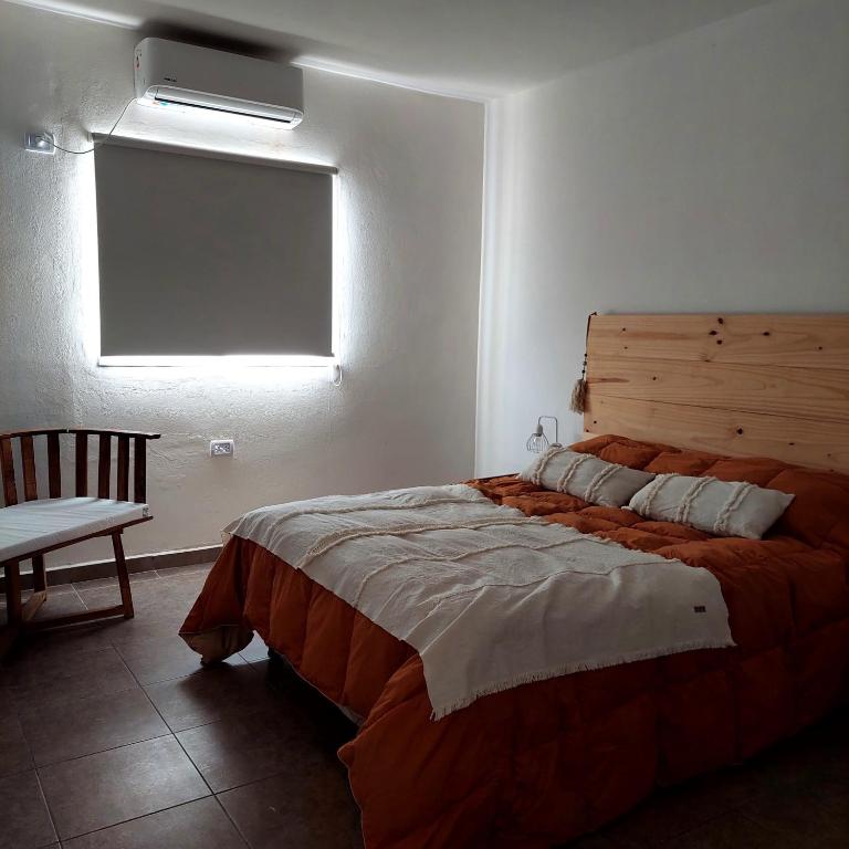 a bedroom with a large bed and a window at Salir del Cráter Apart VALENTIN in Los Sarmientos