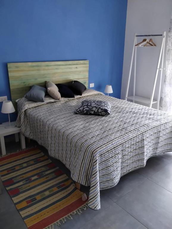 a bedroom with a large bed with a blue wall at Appartamento Mare Blu in Martinsicuro