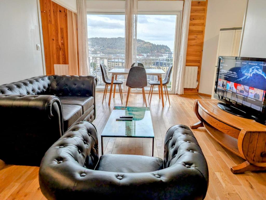 un salon avec un canapé, une table et une télévision dans l'établissement F2 Rouen Centre Gare Boulingrin - possibilité de parking, à Rouen