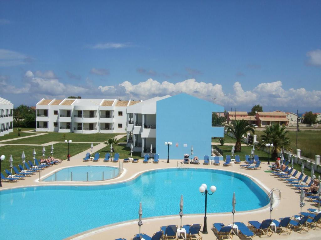 arial view of a large swimming pool with chairs and a building at Stemma Hotel in Sidari