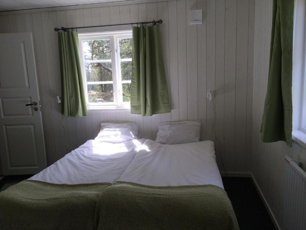 Cama en habitación pequeña con ventana en Ösjönäs, en Tived