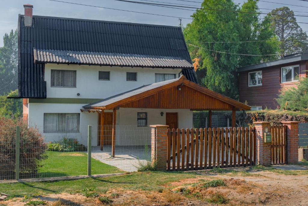 a house with a wooden fence in front of it at Casa Vintage in San Carlos de Bariloche