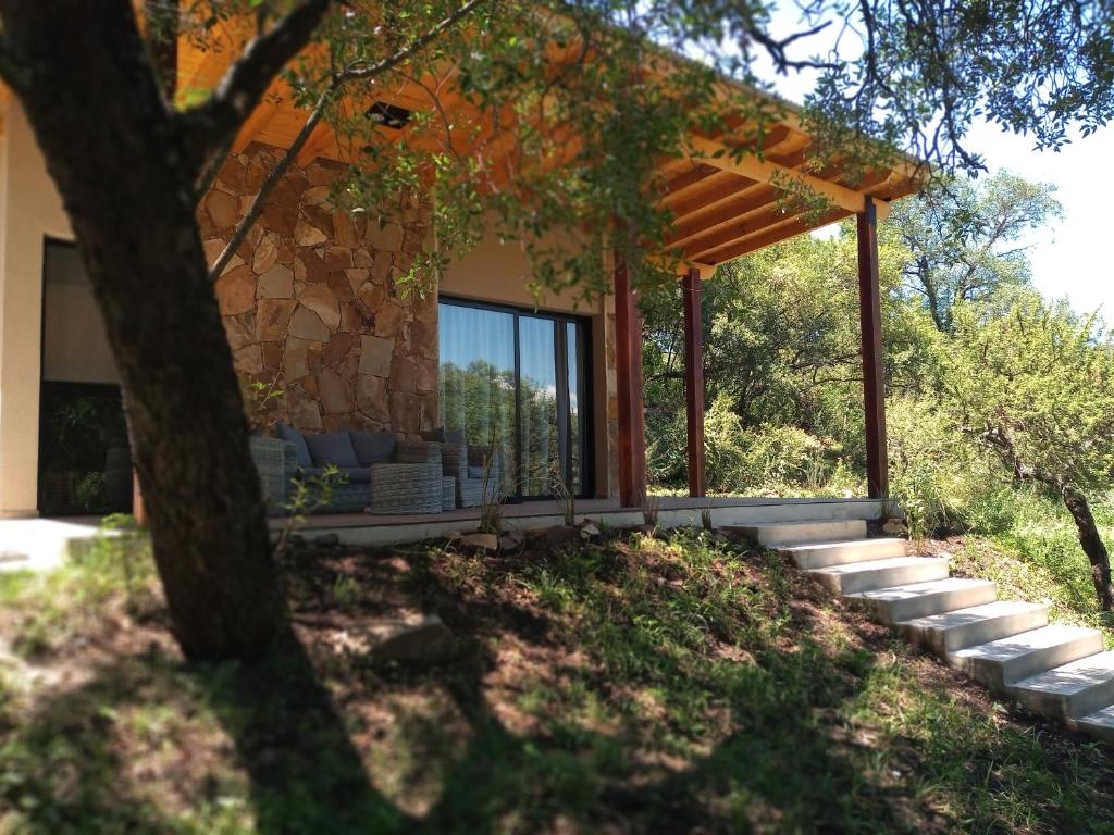 a house with a large window and a patio at VenTeVeo Chakra de Montaña in Atos Pampa