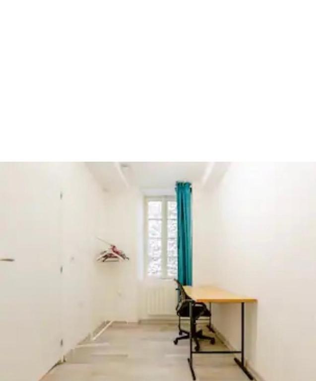 une chambre avec une table et un rideau bleu dans l'établissement Good night, à Chambéry