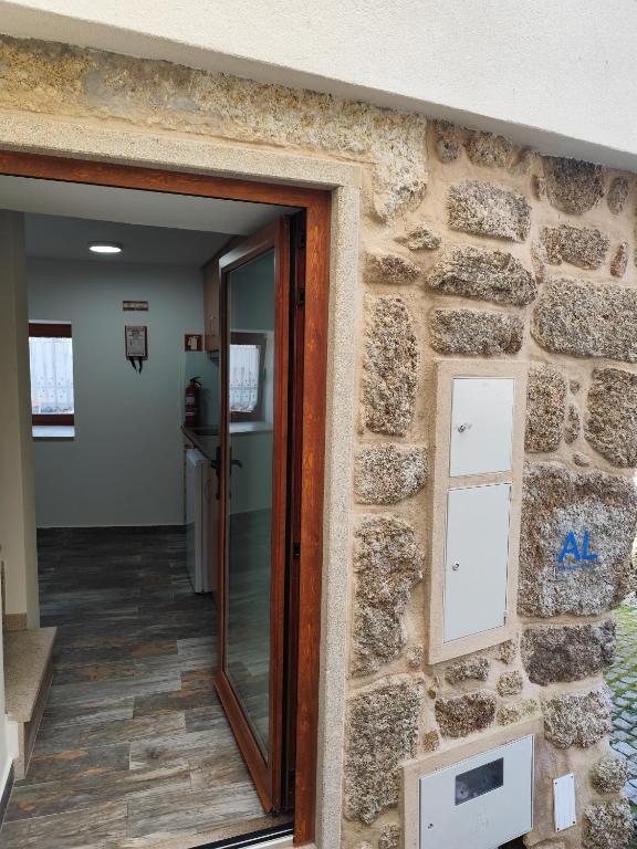 a stone wall with a glass door in a hallway at Casinhas da aldeia-casa da xiquita in Seia