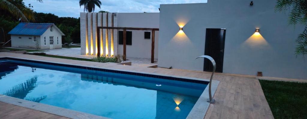 a house with a swimming pool in front of a house at Chalé Estância Morada Nova in Coração de Jesus