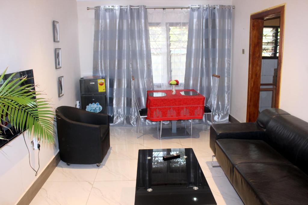 un salon avec un canapé et une table dans l'établissement Green House, 1bdr Apt, 7 min from Airport, à Accra
