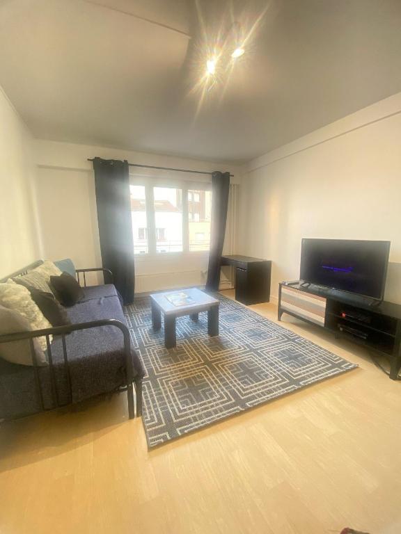un salon avec un canapé et une télévision à écran plat dans l'établissement The Cosy studio Aubervilliers - Metro 12, à Aubervilliers