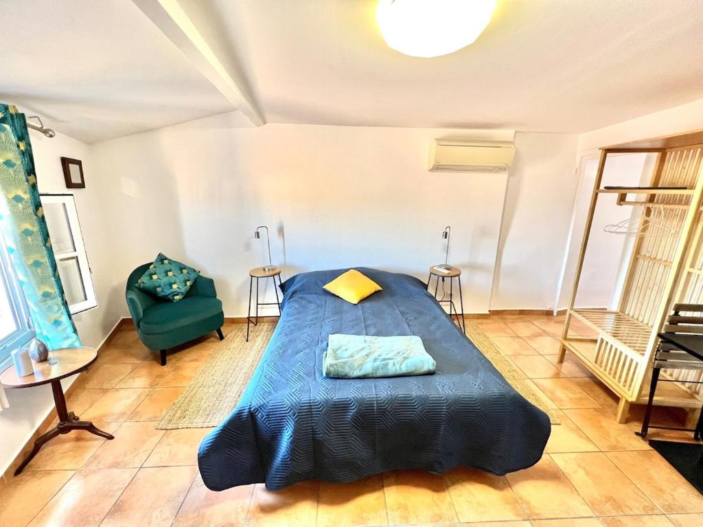 - une chambre avec un lit bleu et une chaise verte dans l'établissement Studio Meublé-Vue Mer-Vieux Hyères- Centre Médiéval Coeur de Ville, à Hyères
