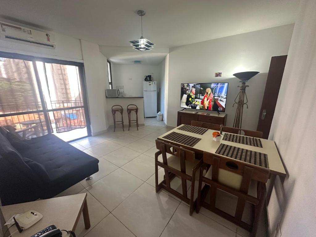 un salon avec un canapé, une table et une télévision dans l'établissement Apartamento Copacabana sistema Apart-hotel, à Rio de Janeiro