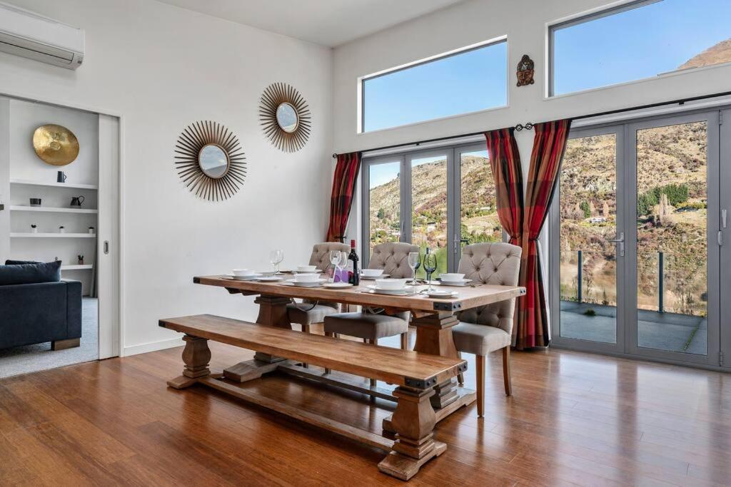 ein Esszimmer mit einem Holztisch und Stühlen in der Unterkunft Huge &amp; Stylish on Shotover 4 Bedrooms in Queenstown