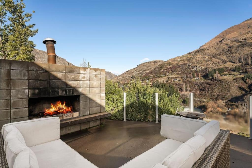eine Terrasse mit zwei weißen Sofas und einem Kamin in der Unterkunft Huge &amp; Stylish on Shotover 4 Bedrooms in Queenstown