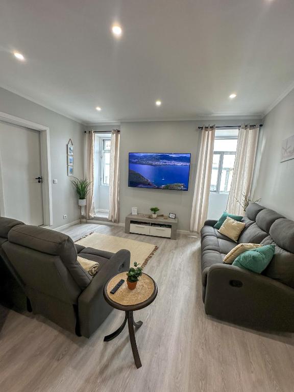a living room with two couches and a tv at Maré Alta - Scenic Seaside Stay with outdoor deck in Vila Franca do Campo