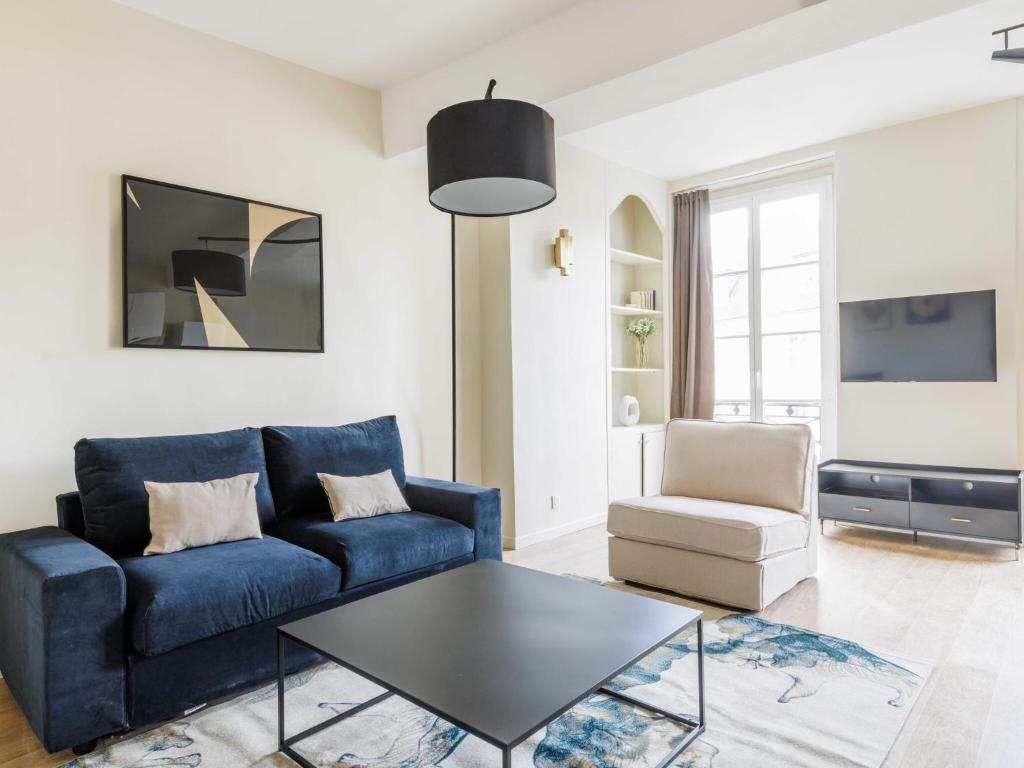 un salon avec un canapé bleu et une table dans l'établissement Cosy apartment - 2BR 5P - Jardin du Luxembourg, à Paris