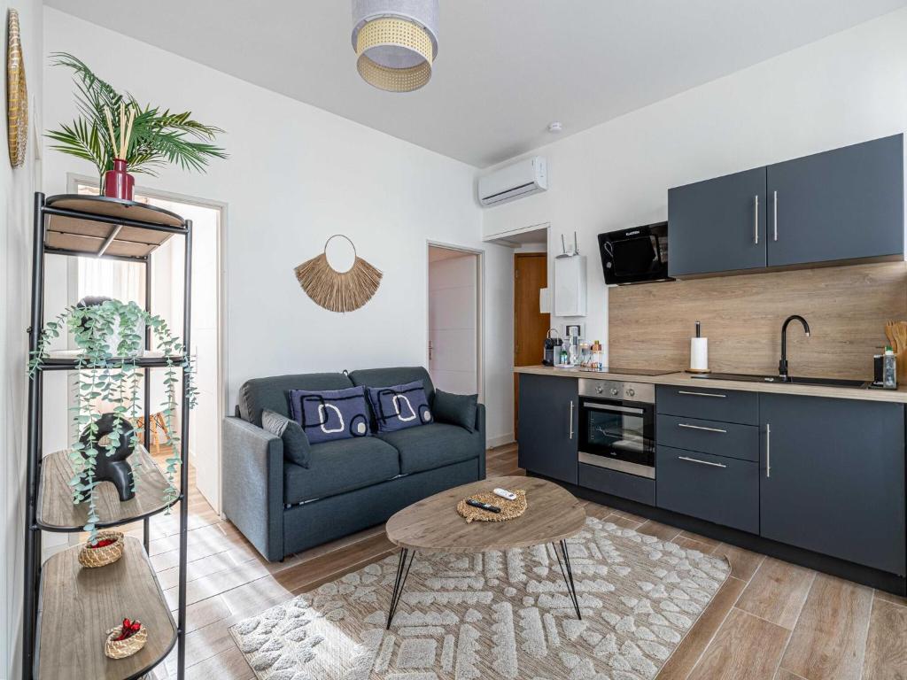 un salon avec un canapé bleu et une cuisine dans l'établissement Sublime 2 bedroom apart - Cannes residential area, à Cannes