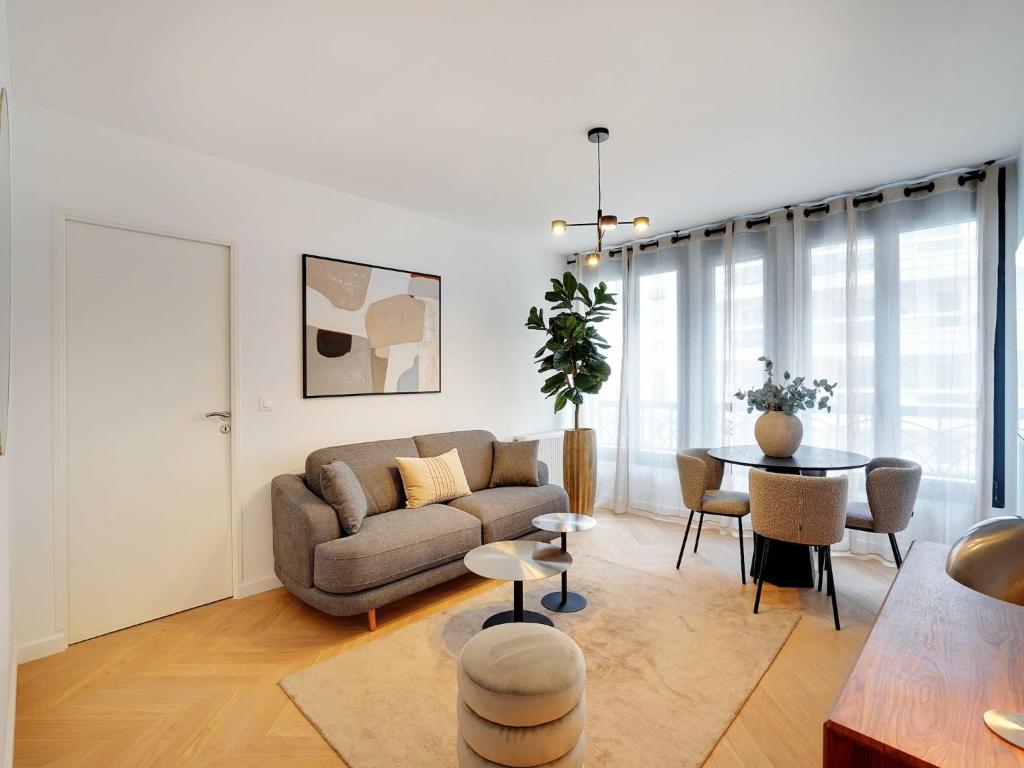 un salon avec un canapé et une table dans l'établissement Sleek & Refined Apartment - Levallois-Perret, à Levallois-Perret