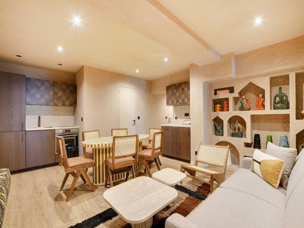 un salon avec une table et des chaises et une cuisine dans l'établissement Exceptional 2BR 6P Apartment - Caire Montorgueil, à Paris