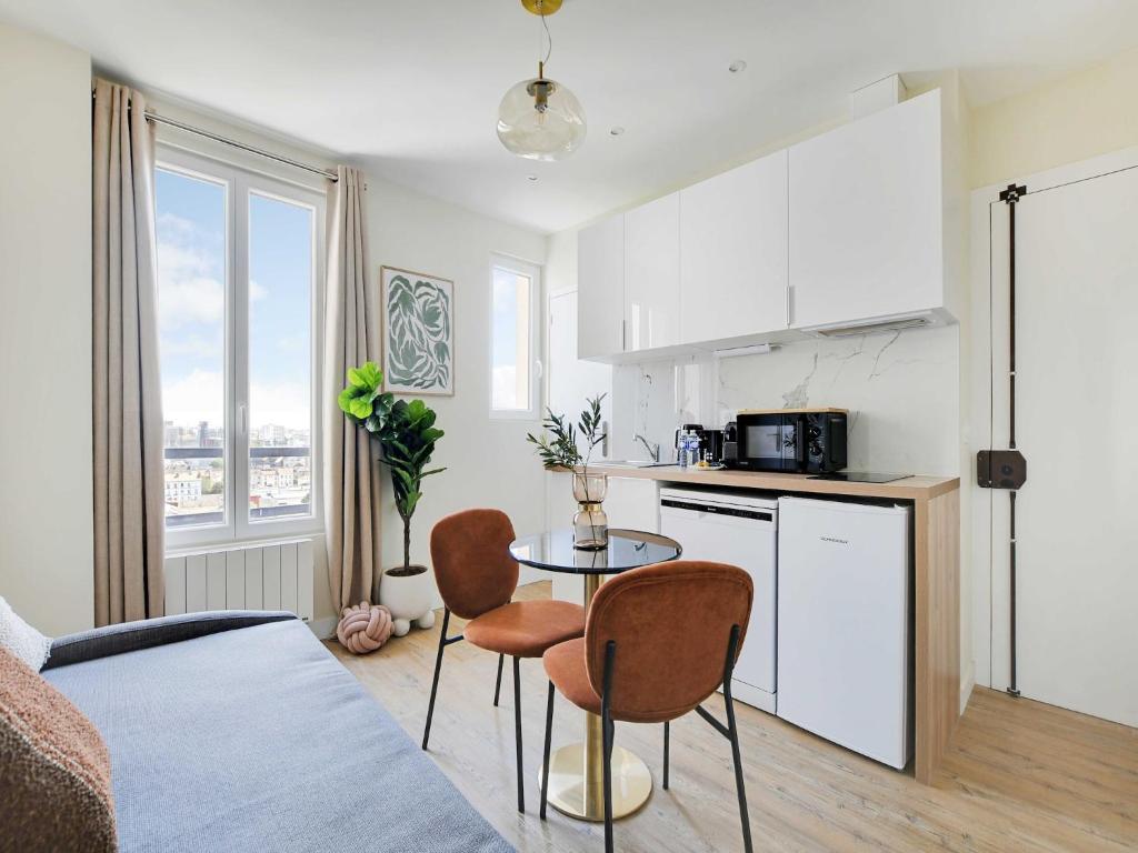 une cuisine avec une table et des chaises dans une pièce dans l'établissement Charming apartment - 1BDR-4P - Ivry-sur-Seine, à Ivry-sur-Seine
