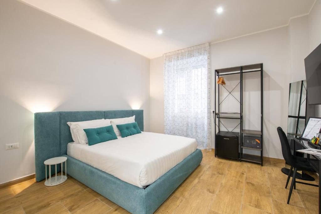 een slaapkamer met een blauw bed en een bureau bij Ventuno Dei Luxury Suites San Giovanni in Rome