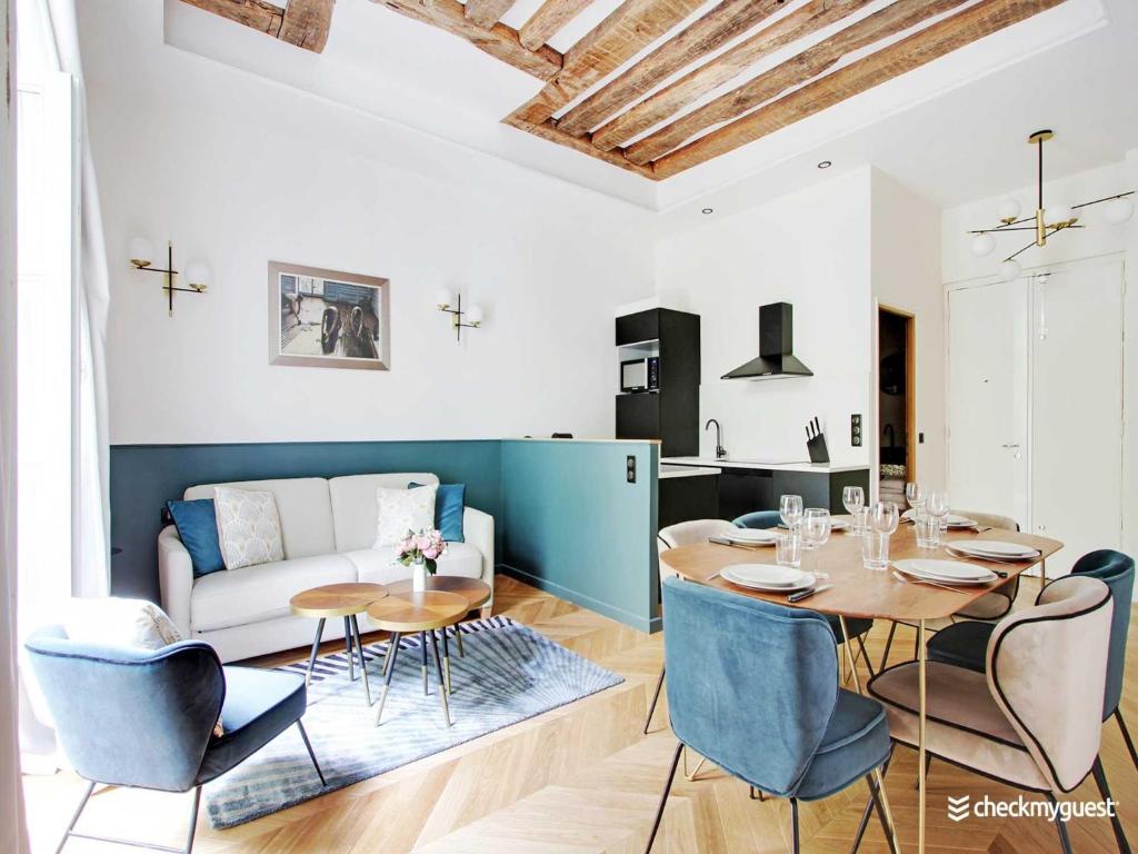un salon avec une table, des chaises et un canapé dans l'établissement Stylish apartment - 2BR 6P - Le Marais, à Paris
