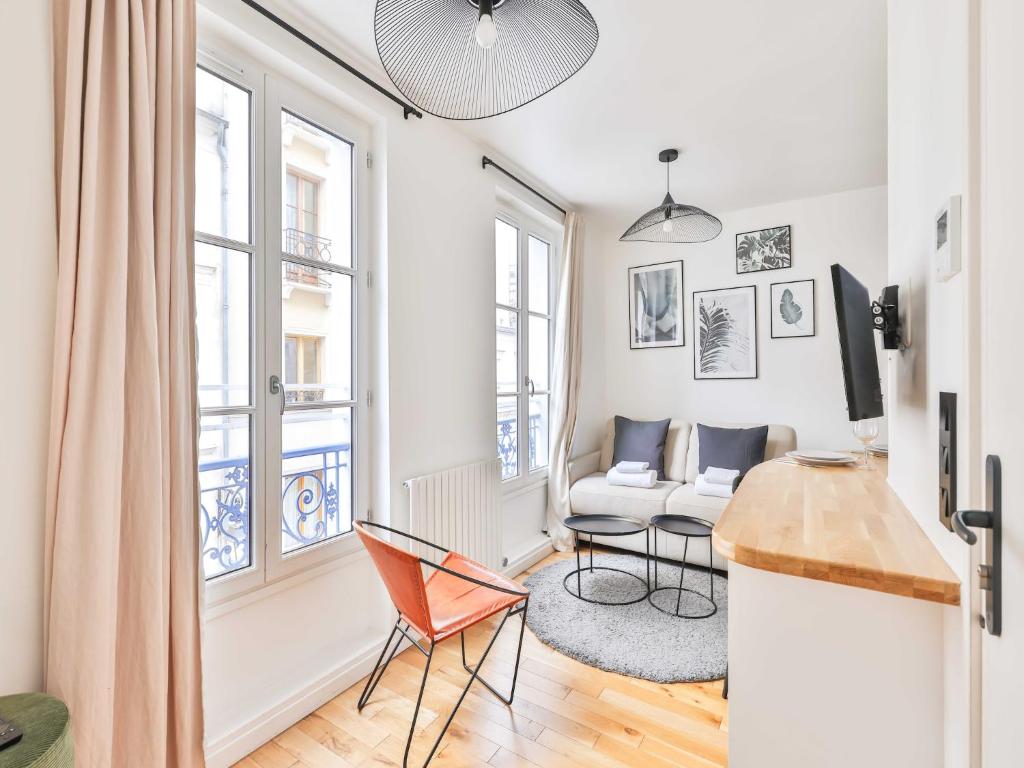 un salon avec une table, des chaises et un canapé dans l'établissement Amazing Apartment 1BR 4P - Crémieux - Gare de Lyon, à Paris
