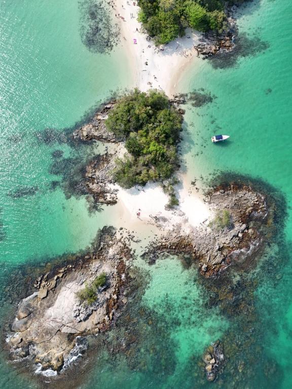 an island with a boat in the water at Privilège Passeio de Lancha em Angra dos Reis e Ilha Grande in Angra dos Reis