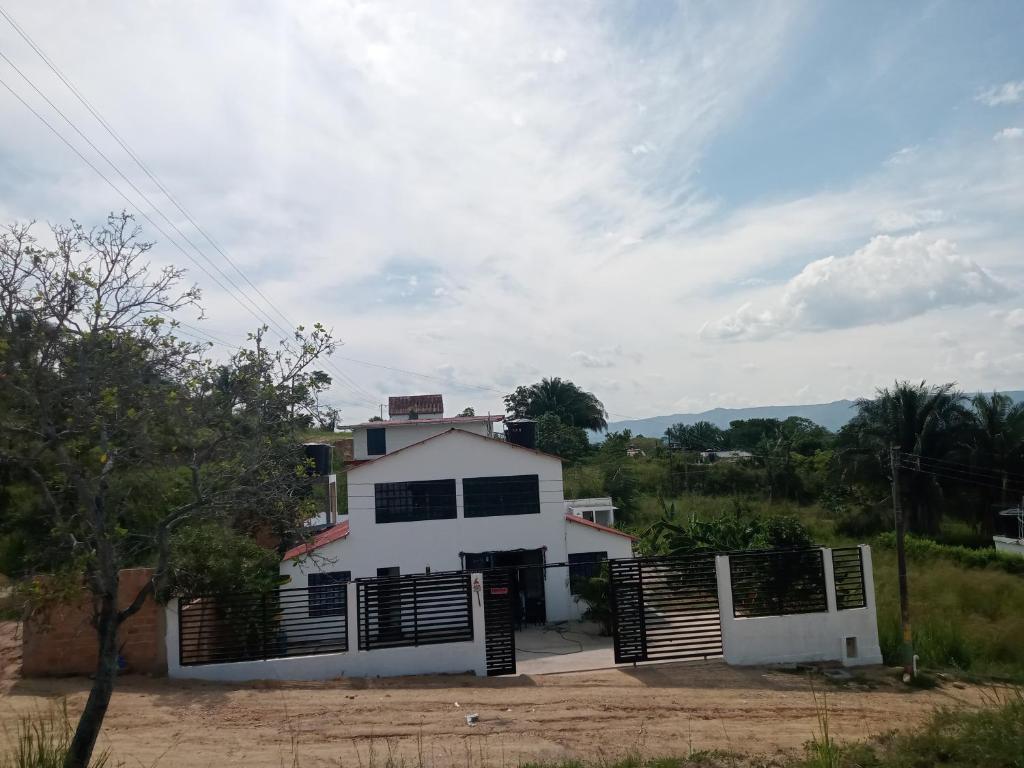 a white house with a gate in front of it at Casa Cruz Melgar in Melgar