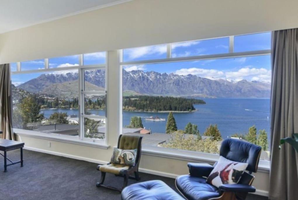 a living room with a large window with a view of the water at The BIGGEST & BEST VIEWS 3 Bedrooms WALK To Town in Queenstown