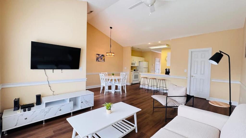 a living room with white furniture and a flat screen tv at Adorable 1BR condo with pool view at Magnolia in Myrtle Beach